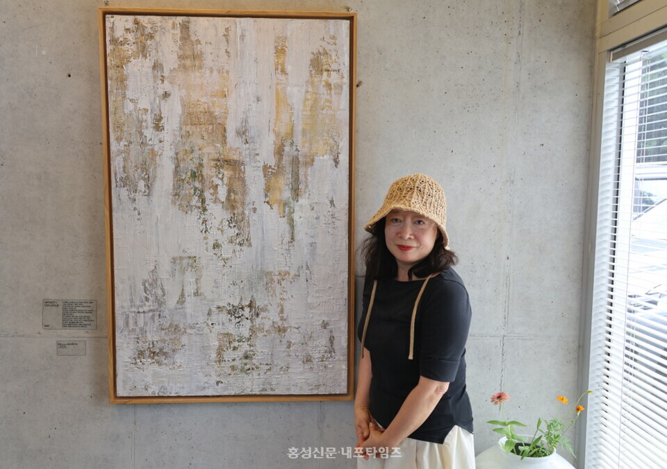 마음의 평화를 주로 작품에 담는다는 이선경 작가가 ‘흔적으로 남겨진 기억’이란 작품 옆에 서 있다.