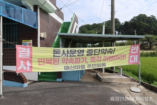 홍북읍 매산마을회관에 돈사 중단약속을 이행하라는 현수막이 내걸렸다. 