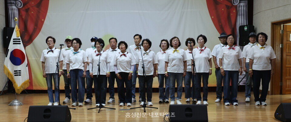 은하면 노래교실 회원들이 주민총회 국민의례 중 애국가를 부르고 있다.