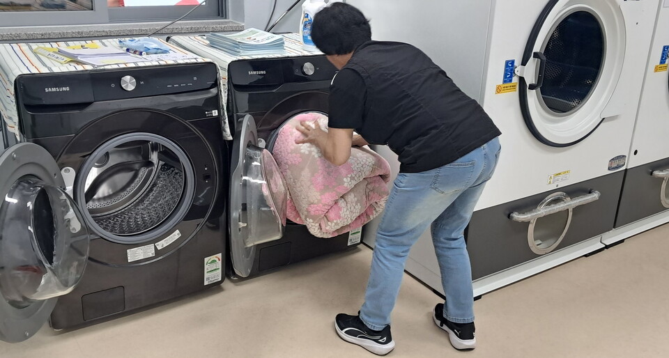 ‘세탁 돌봄’을 수거한 빨랫감을 당일에 다시 배달하며, 대상자의 안부도 함께 살핀다. 사진=구항면지역발전계획단