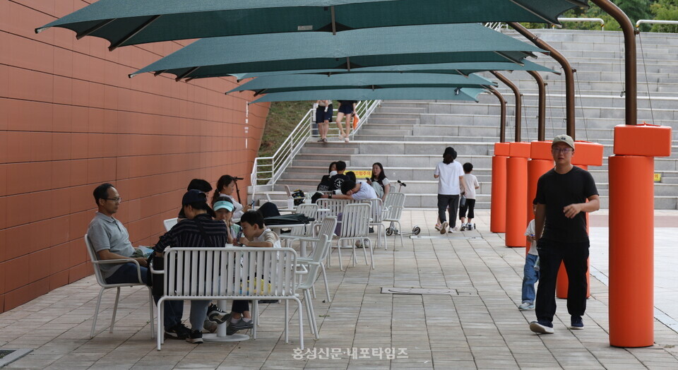 충남도서관 앞 벤치에서 여유를 즐기는 사람들.