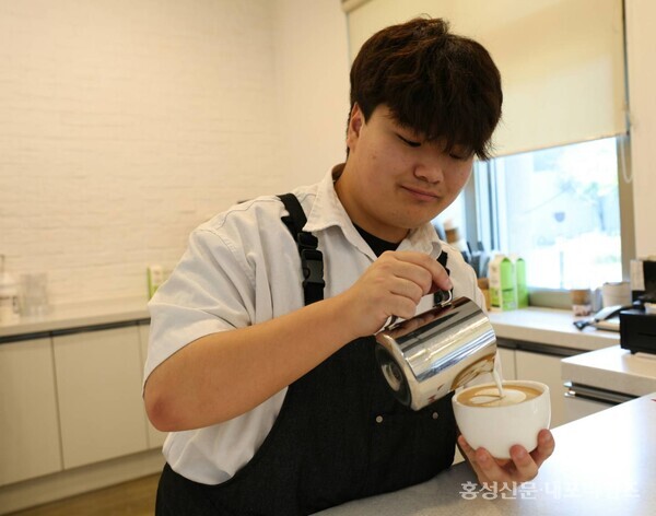 홍성읍행정복지센터 내 '카페-인'에 근무하는 이재현 씨가 라떼아트를 선보이며 전국장애인바리스타대회 본선에 진출했다. 