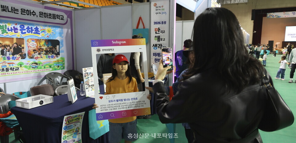 은하초등학교 홍보 부스를 찾은 한 아이가 기념촬영을 하고 있다.
