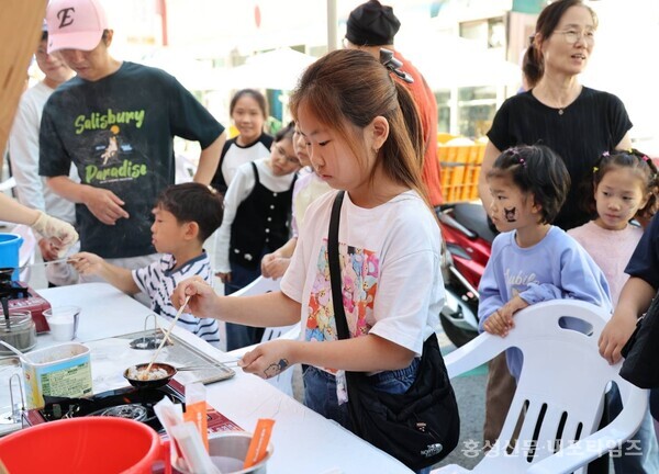 광천토굴새우젓·조미김대축제에서 한 아이가 김달고나 체험을 하고 있다. 