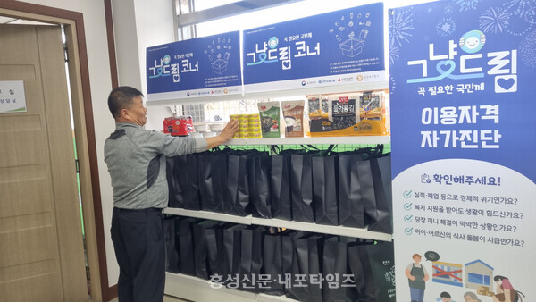 청로쉼터 이철이 대표가  홍성군푸드마켓·뱅크에서 그냥드림 식품을 살펴보고 있다. 